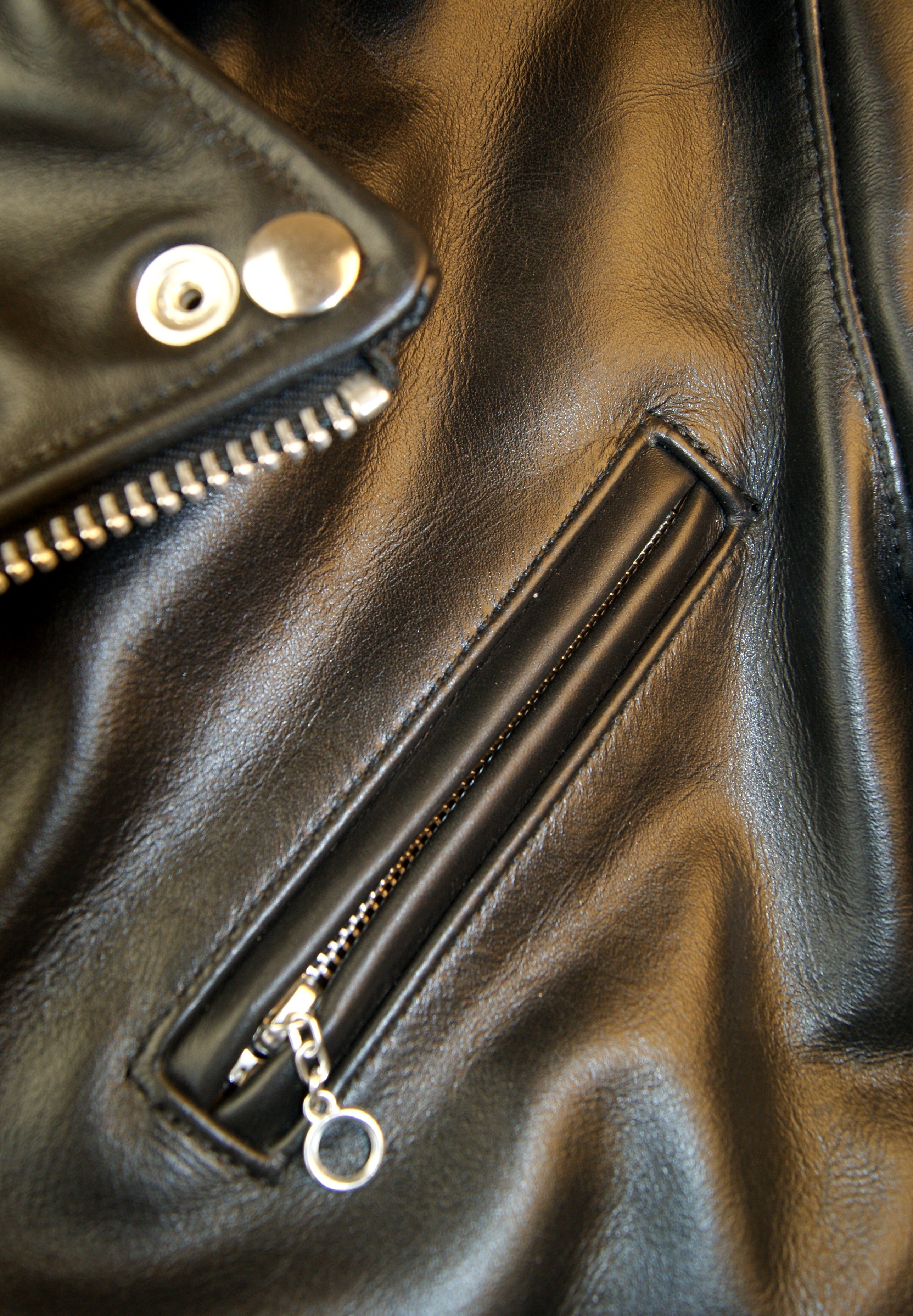 Close-up of angled chest pocket with nickel ring pull.